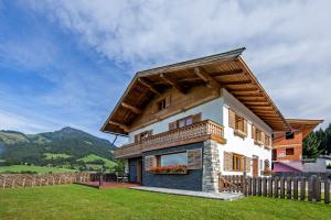 a small house with a wooden roof at Ferienhaus Rauter in Oberndorf in Tirol