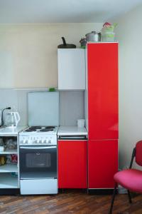 een keuken met rode kasten en een fornuis bij Panorama-hostel in Kiev