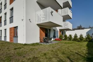 zewnętrzny widok na biały budynek z trawnikiem w obiekcie LTC Apartments Malczewskiego Centrum w Gdańsku