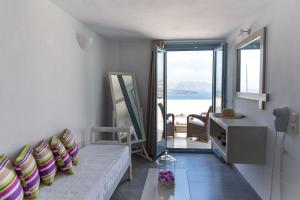 - un salon avec un canapé et une vue sur l'océan dans l'établissement Caldera Romantica Hotel, à Akrotiri