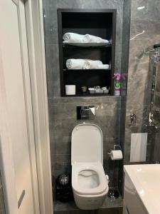 bagno con servizi igienici, lavandino e asciugamani. di Fountain Appartement a Lviv