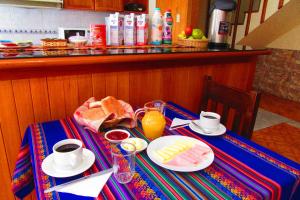 una mesa con comida para el desayuno y bebidas en ella en Hospedaje Kamila, en Cusco