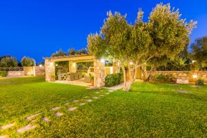 a garden with a tree and a house at Elaia Villas in Pythagoreio