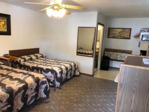 a hotel room with two beds and a ceiling fan at Black Hills Cabins at Quail's Crossing in Hill City +32 photos