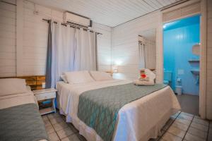 um quarto com uma cama grande e uma janela em EcoCharme Pousada Arquipélago em Fernando de Noronha