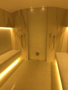 y baño con ducha con luces. en On Beach-Mamaia Residence, en Mamaia Nord – Năvodari