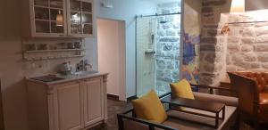 a kitchen with a sink and a table and chairs at Apartmani Armonia in Perast