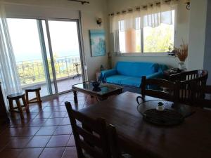 a living room with a blue couch and a table at Kalivakia View in Tsoukalades
