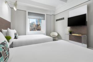 Habitación de hotel con 2 camas y TV de pantalla plana. en Paramount Hotel Times Square, en Nueva York