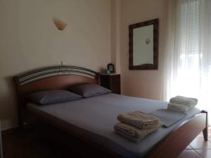 a bedroom with a bed with towels on it at Kalivakia View in Tsoukalades