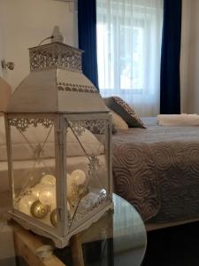 een kamer met een bed en een glazen tafel met een lantaarn bij SZiGET23 in Ábrahámhegy