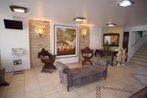 uma sala de estar com cadeiras e um quadro na parede em Royal Plaza Hotel em Apucarana