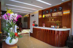 a lobby of a hotel with a counter and flowers at Mira Hotel Quy Nhơn in Quy Nhon
