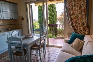 a kitchen and living room with a table and chairs at Villa Pineland in Borghetto Santo Spirito