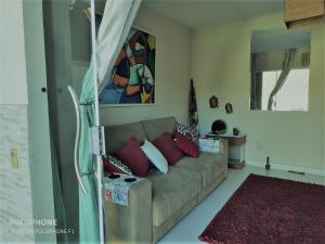 una sala de estar con un sofá marrón con almohadas rojas en Duplex DE LUX com piscina,Churrasqueira TOTALMENTE PRIVATIVO en Nova Friburgo