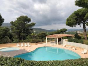 a swimming pool with chairs and a gazebo at Appartement Domaine Maxime Park in Sainte-Maxime