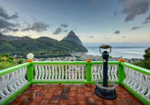un balcone verde con vista sull'oceano e sulle montagne di Villa Des Pitons a Soufriere