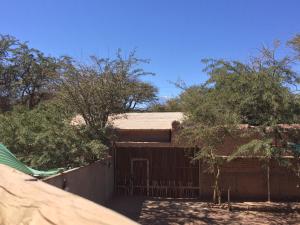 a house with a gate and trees in front of it at Refugio Don Natu in San Pedro de Atacama
