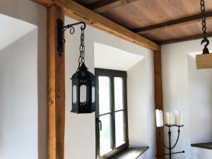 una lámpara de araña negra colgada en una habitación con ventana en Ferienwohnung LATERNENSTUBE mit großem Familienbett für 8 Personen en Leppersdorf