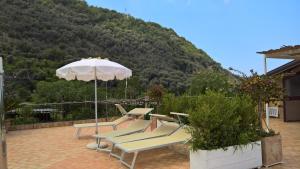 un gruppo di sedie e un ombrellone su un patio di Villa Flavia a Sant'Agnello