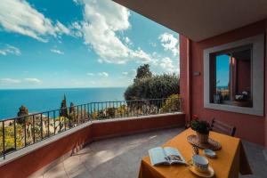 a balcony with a table and a view of the ocean at The charming house in Taormina