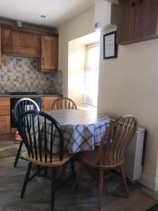 a kitchen with a table and two chairs and a table and a kitchen at Old Mill Cottage in Swinford
