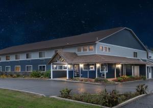 a large building with a parking lot at night at Northwoods Inn and Suites in Ely