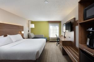 a hotel room with a bed and a television at Holiday Inn Express & Suites Milton East I-10, an IHG Hotel in Milton