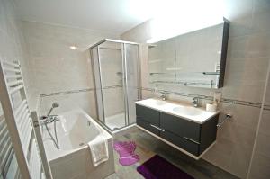 a bathroom with a sink and a shower and a tub at Schmitten Finest Apartments by All in One Apartments in Zell am See +62 photos