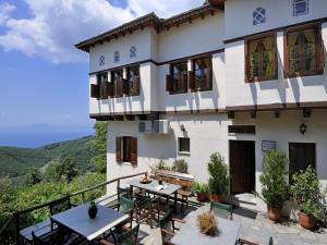 Casa con balcón con mesa y sillas. en Hotel Stoikos, en Vizítsa