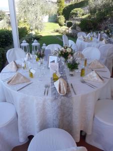 einem Tisch mit weißen Tischdecken und Besteck in der Unterkunft Le Gemme Suite B&B in Verona