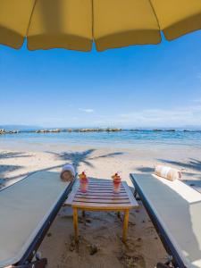 a picnic table on the beach under an umbrella at Costa Sur Resort & Spa in Puerto Vallarta