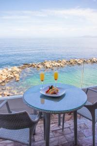 uma mesa com um prato de comida e dois copos de sumo de laranja em Costa Sur Resort & Spa em Puerto Vallarta