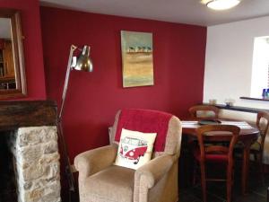 a living room with a table and a chair and a table and a lamp at Causeway Cottage in Cartmel