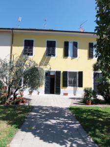 una casa gialla con persiane nere e un vialetto di Casa Magnolia a Lucca