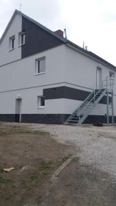 a large white building with a staircase on the side of it at Apartment Simona in HoÅ¡Å¥ka