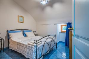 una camera con letto e pavimento piastrellato blu di Domus Le Postali a Vico Equense
