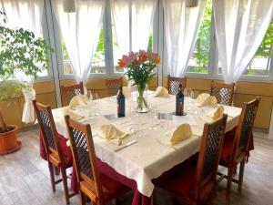 a dining room with a table with a vase of flowers at Hotel della Posta in Biasca
