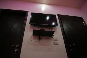 una TV a schermo piatto su un muro accanto a due porte di Queen Pyramids View Inn a Il Cairo