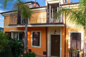 pomarańczowy dom z balkonem i drzwiami w obiekcie Villa Pineland w mieście Borghetto Santo Spirito