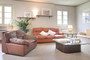 a living room with a leather couch and a coffee table at Relais Villa Isabel in Pietrasanta