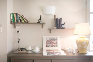 a desk with a lamp and a picture and books at Relais Villa Isabel in Pietrasanta