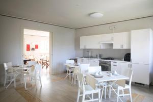 a kitchen and dining room with white tables and chairs at Relais Villa Isabel in Pietrasanta