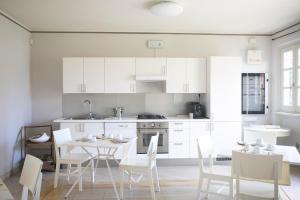 a kitchen with white cabinets and a table and chairs at Relais Villa Isabel in Pietrasanta