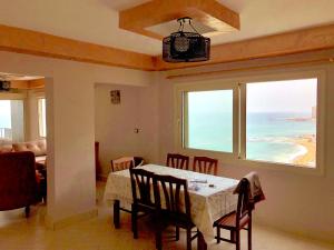 a dining room with a table and a view of the ocean at Toscanini Apartament اول صف مباشره in Alexandria