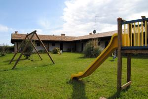 un parque infantil con un tobogán en un patio en Agriresidence San Pietro, en Bibione