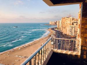 a view of a beach and the ocean from a balcony at Toscanini Apartament اول صف مباشره in Alexandria