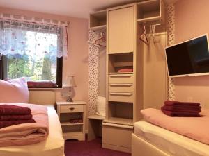a bedroom with two beds and a tv in a closet at Ferienwohnung Baer in Hoppegarten