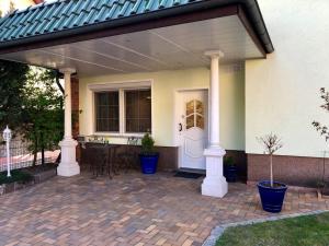 a patio with a white door and columns and a table at Ferienwohnung Baer in Hoppegarten