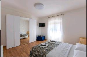 ein Schlafzimmer mit einem großen Bett und einem Spiegel in der Unterkunft Rina's House La Spezia in La Spezia